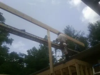 Carpenter setting a ridge beam over a new addition frame — Ice Dam Removal by Roofing Brothers in Helenville