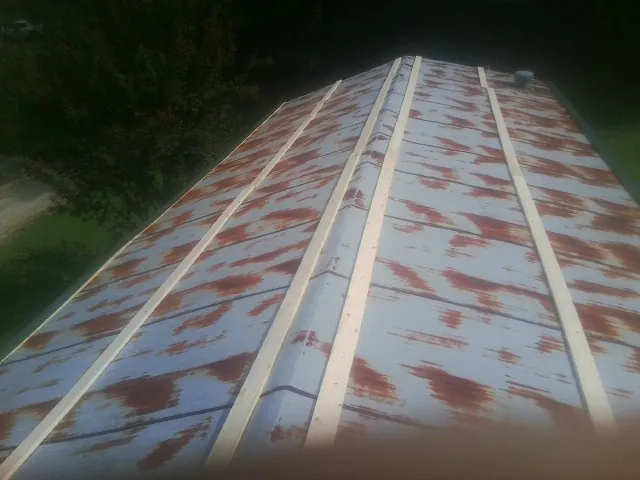 Rusted metal roof panels with new wood purlins before replacement — Storm Damage Roof Repair in Helenville by Roofing Brothers