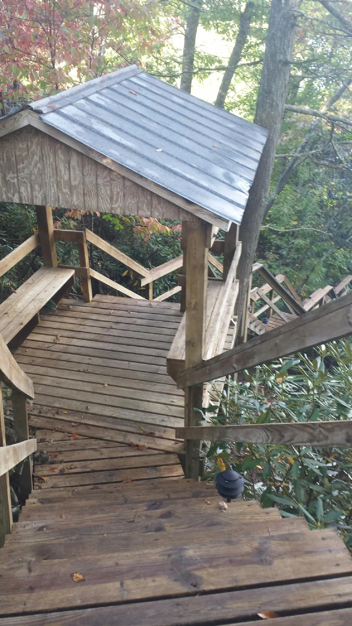 Metal roofed shelter over wooden steps on a wooded walkway — Skylight Repair & Installation work by our crew in Helenville