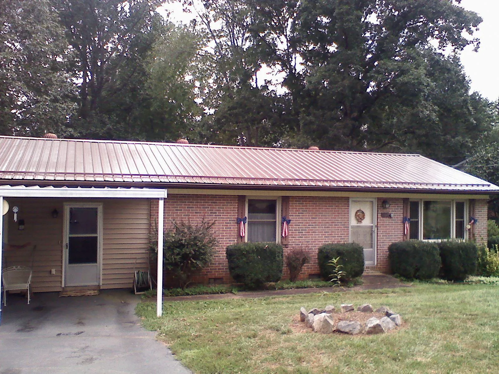 Bronze metal roof and carport on a brick ranch home — Roof Repair work by our crew in Helenville